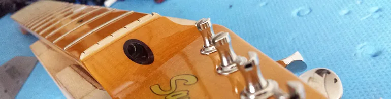 Mesure de la courbure du manche à la 8e frette avec une feuille calibrée