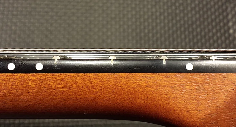 Manche d’une guitare ajusté pour jouer avec les cordes basses