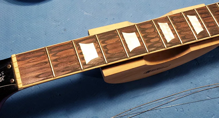 Touche d’une guitare avec frettes et marqueurs