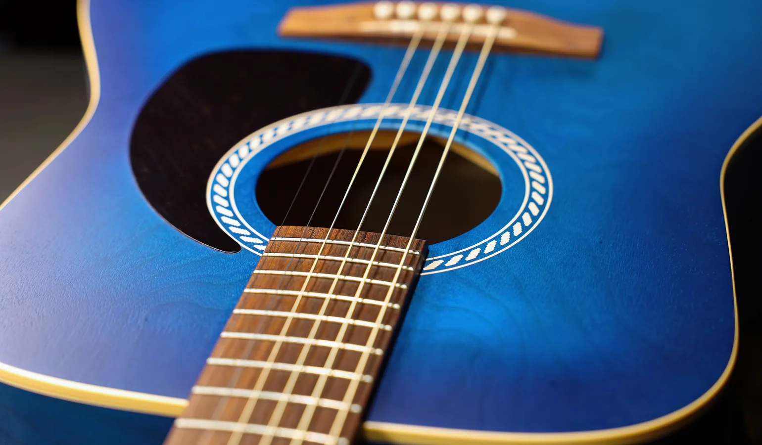 Corps d'une guitare acoustique — close-up sur le bois et la rosace