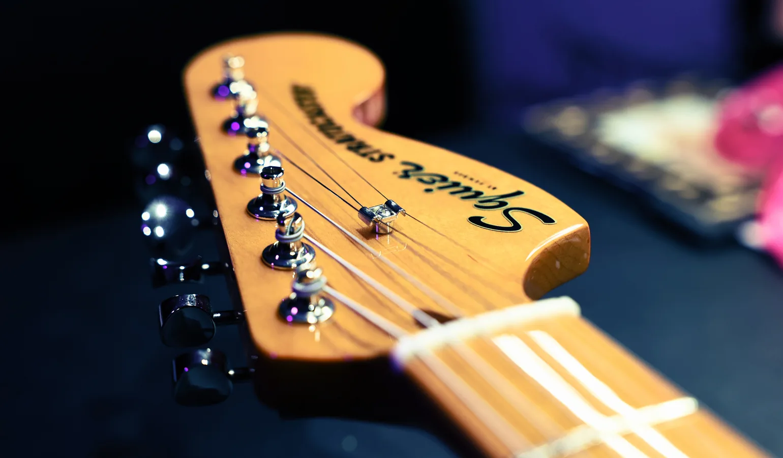 Tête de guitare électrique Squier Stratocaster — close-up des mécaniques et du sillet de tête